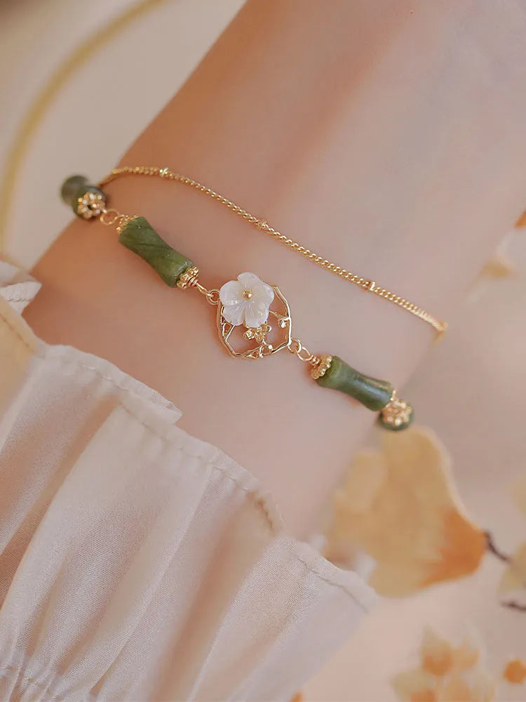 Handcrafted natural olivine bracelet with double layer design and twin Bells of Ireland charms.