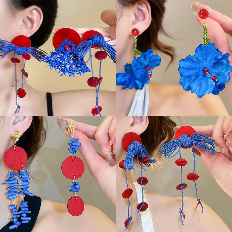 Geometric women's earrings with round blue cloth accents and silver metal details on a white background.