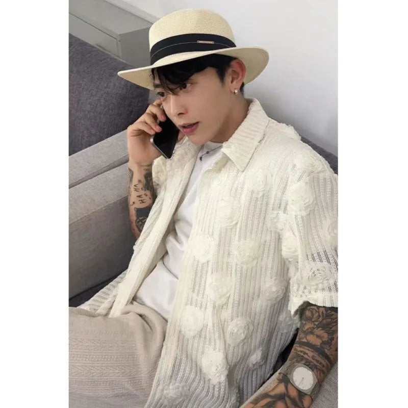 Man wearing a beige loose-fit short sleeve shirt with a textured three-dimensional floral print pattern.