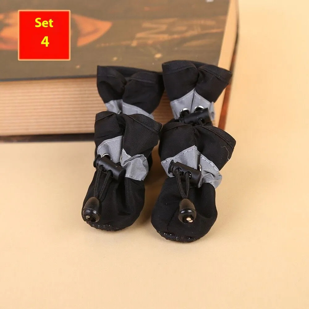 Set of four cloth dog shoes with soft soles in assorted colours on a neutral background