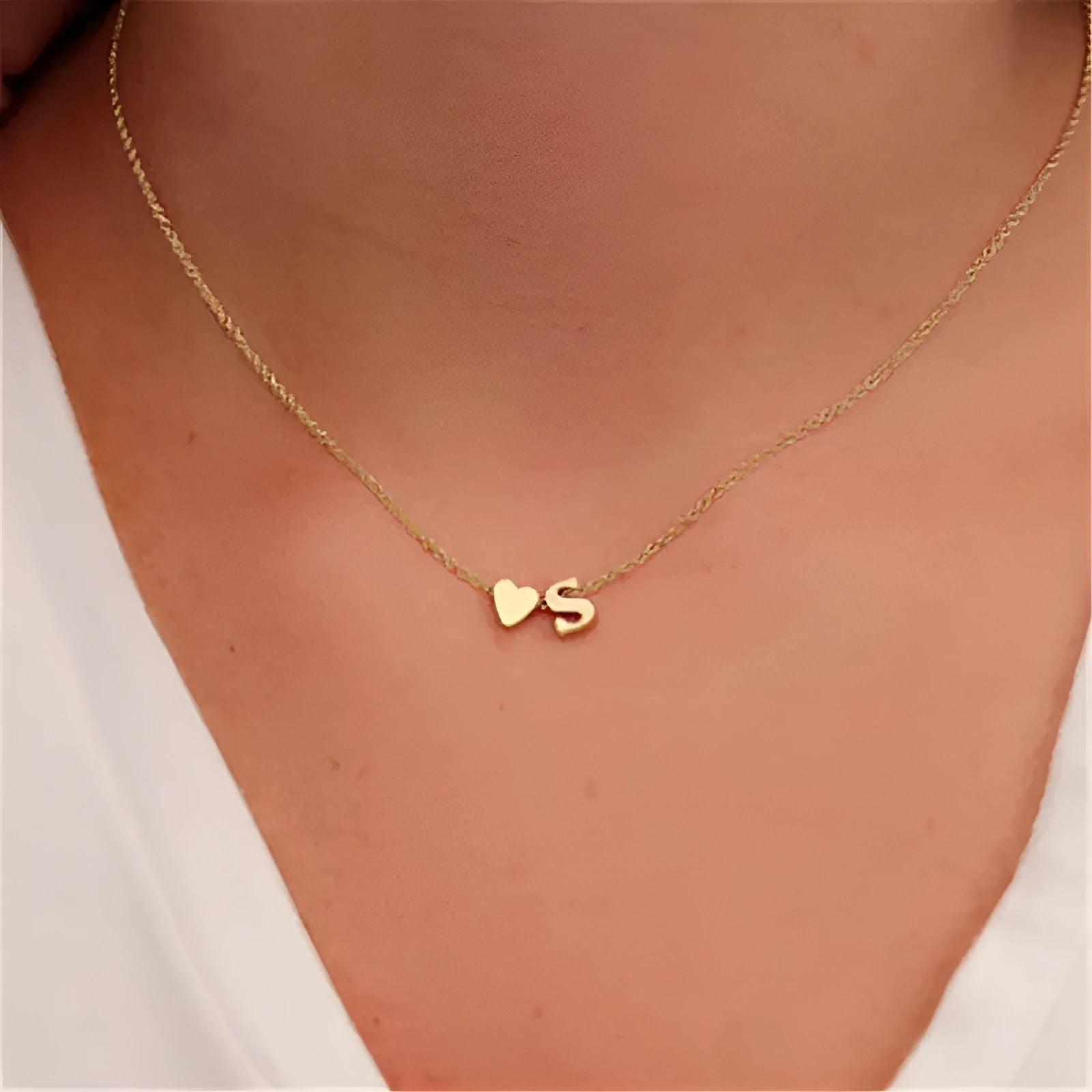 Gold and silver alloy peach heart shaped letter pendant necklace charm on a chain.