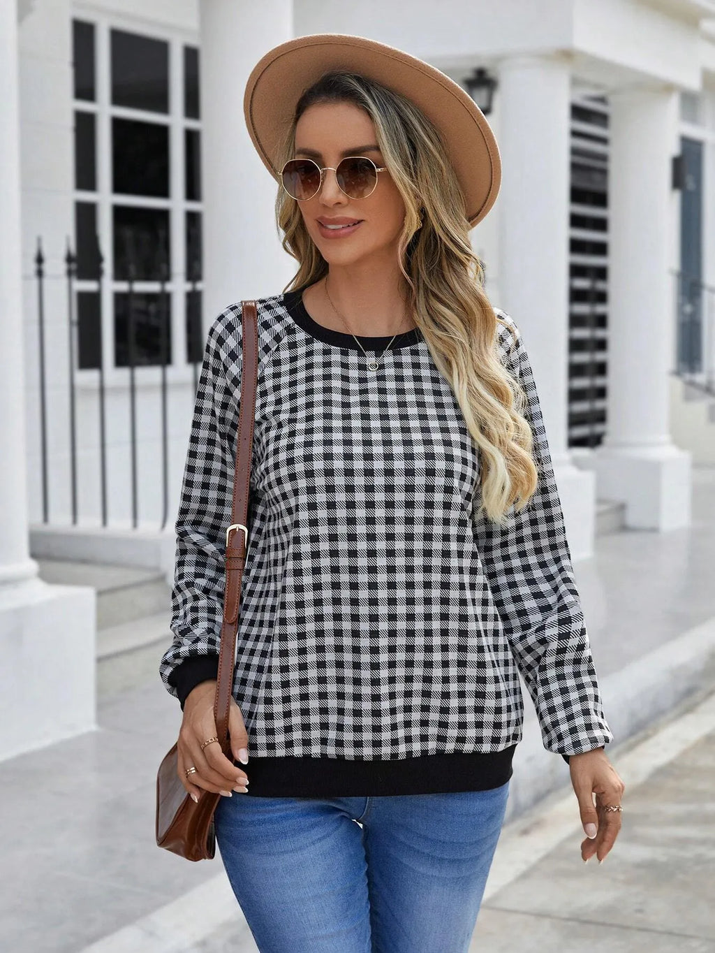 Black polyester pullover sweater with a plaid printed pattern and long sleeves.