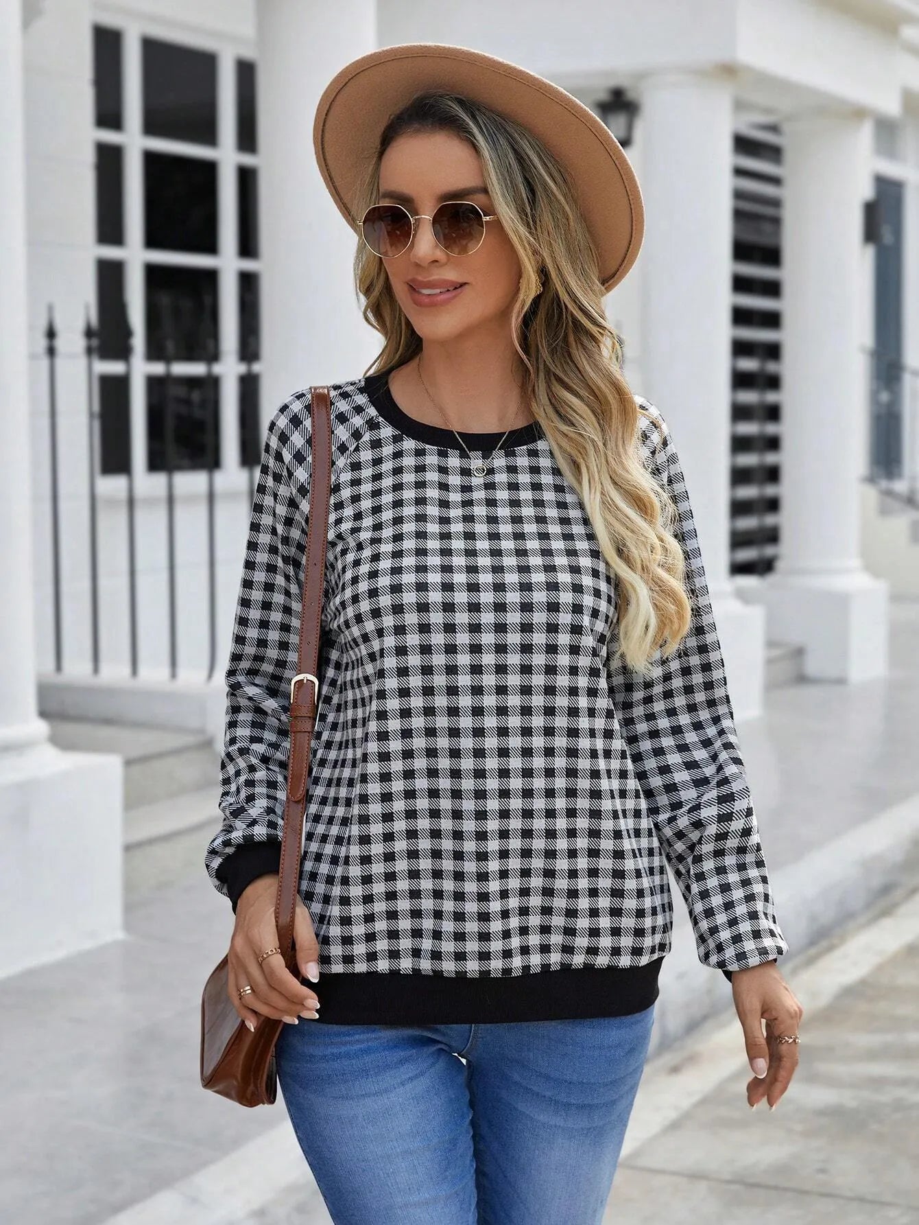 Black polyester pullover sweater with a plaid printed pattern and long sleeves.