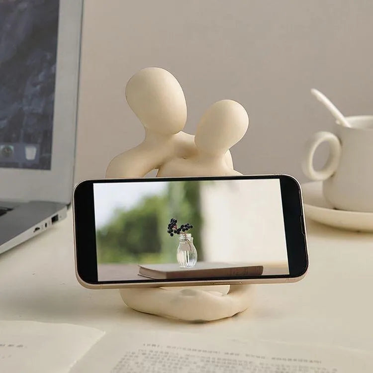 Modern couple resin statue in milky white or gold on a wooden surface.