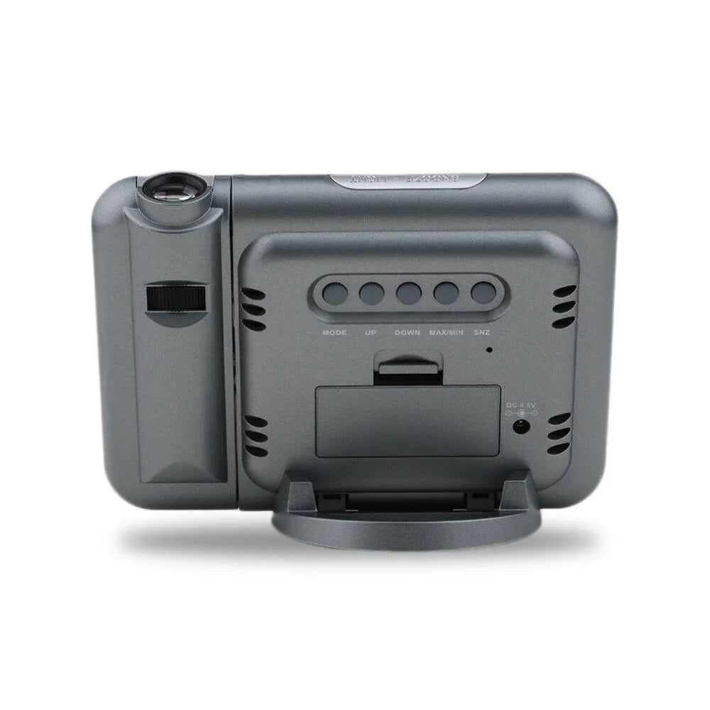 Black digital projection alarm clock with temperature and humidity display on bedside table