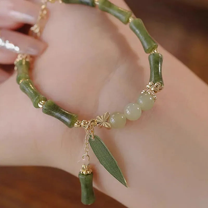 Chinese style handmade glass bead bracelet with bamboo joint elements on a white background.