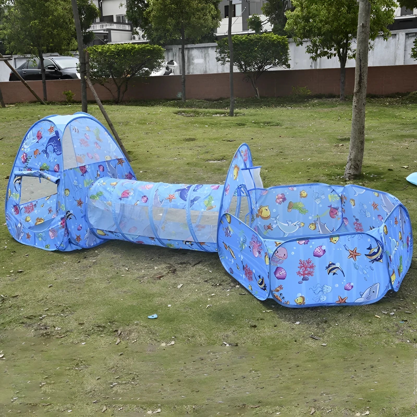 Colourful three-in-one children's play tent with cartoon design, featuring a fabric tent, ball pool, and plastic tunnel.