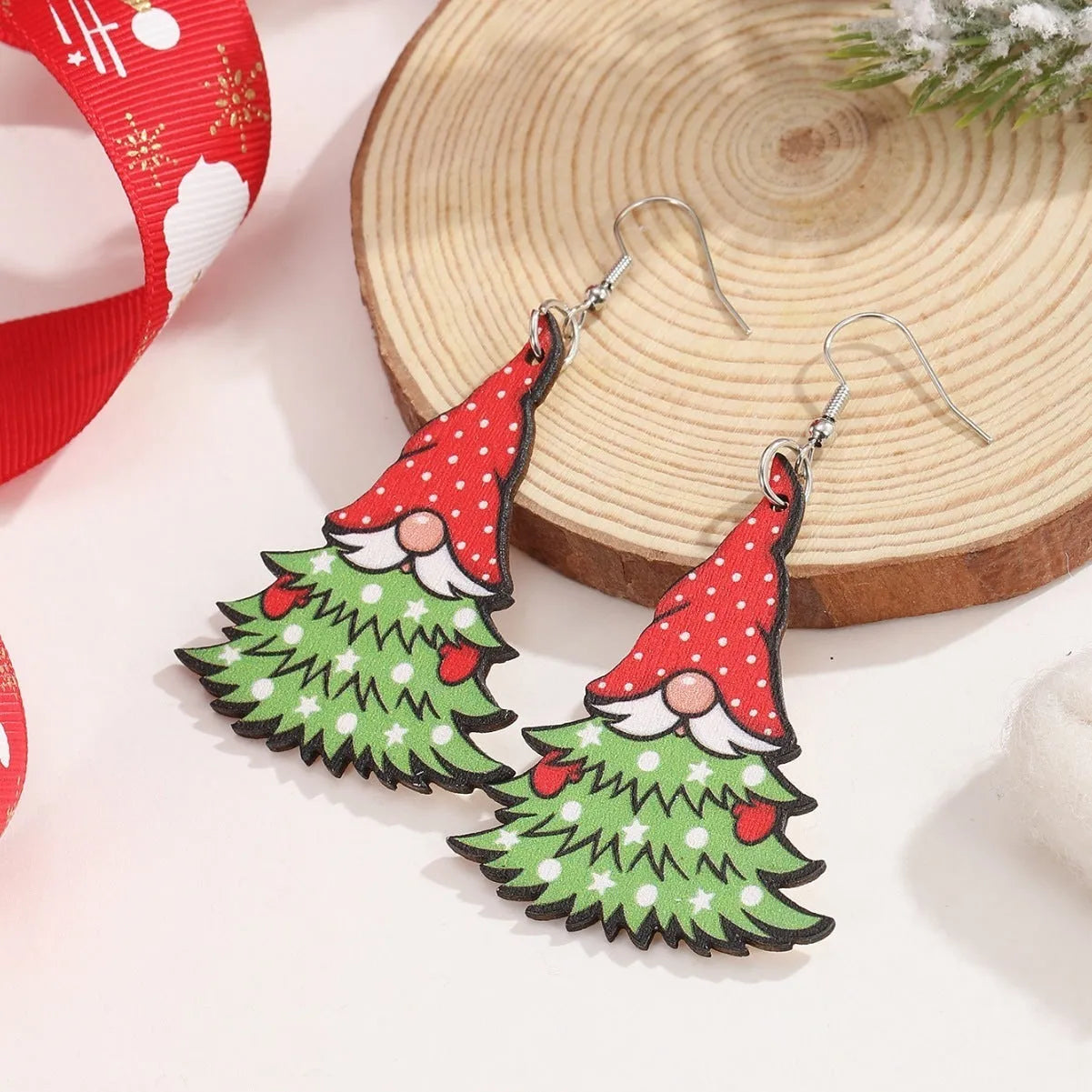Wooden Christmas earrings with geometric shapes showing printed tree and snowman designs