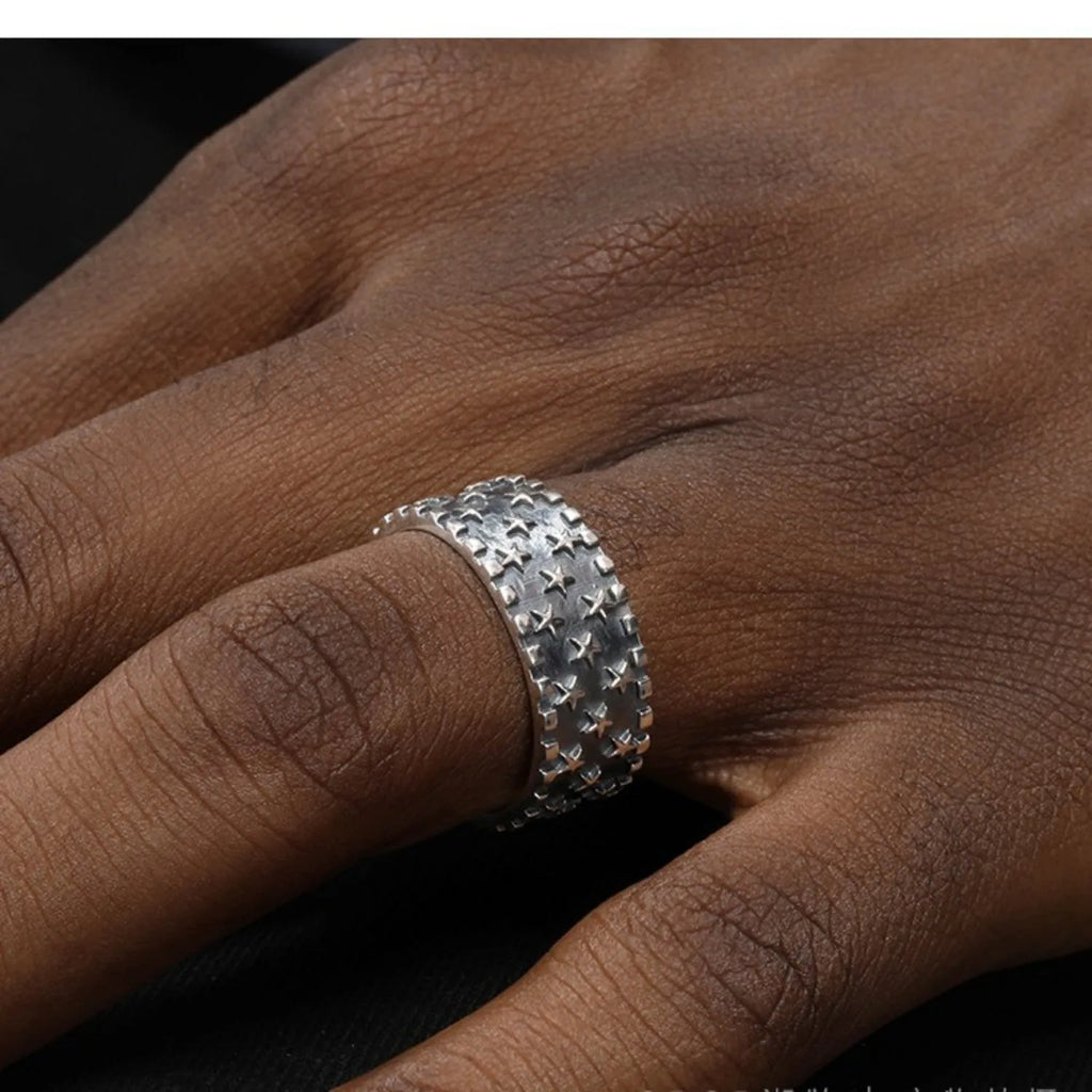 Adjustable open-ended sterling silver ring with a five-pointed star design.
