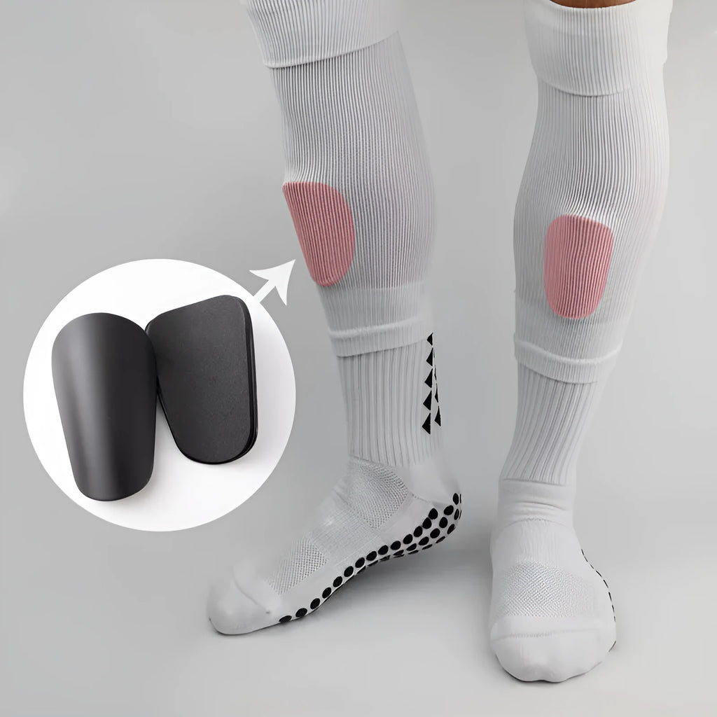 Pair of PU mini shin guards for sports protection in black, shown on a leg.