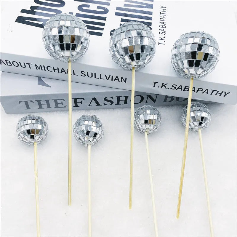 Glass disco ball cake decoration with wooden stick on a birthday cake