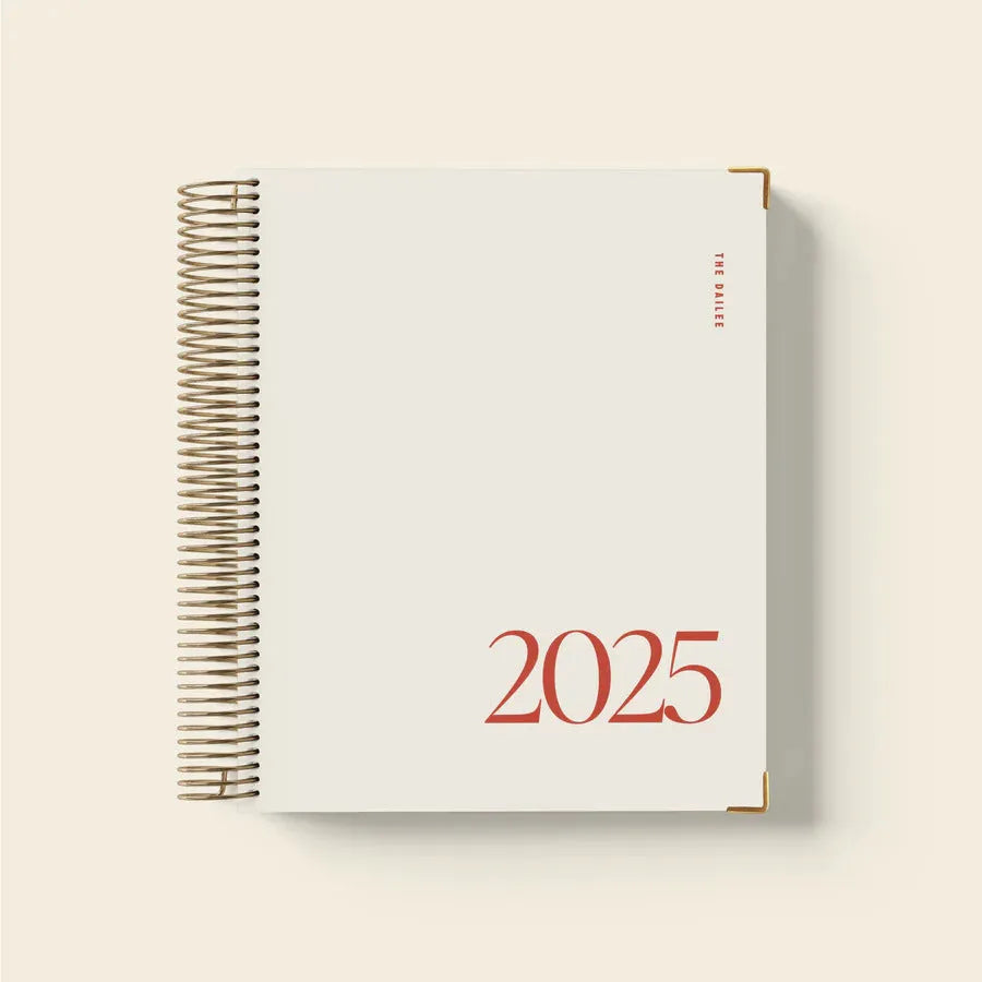 Cherry red spiral coil notebook open on a desk showing paper pages and binding.