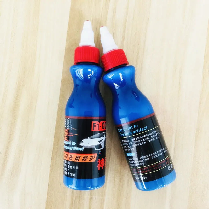 Small blue car scratch repair agent bottle with integrated wiping tool for automotive paintwork
