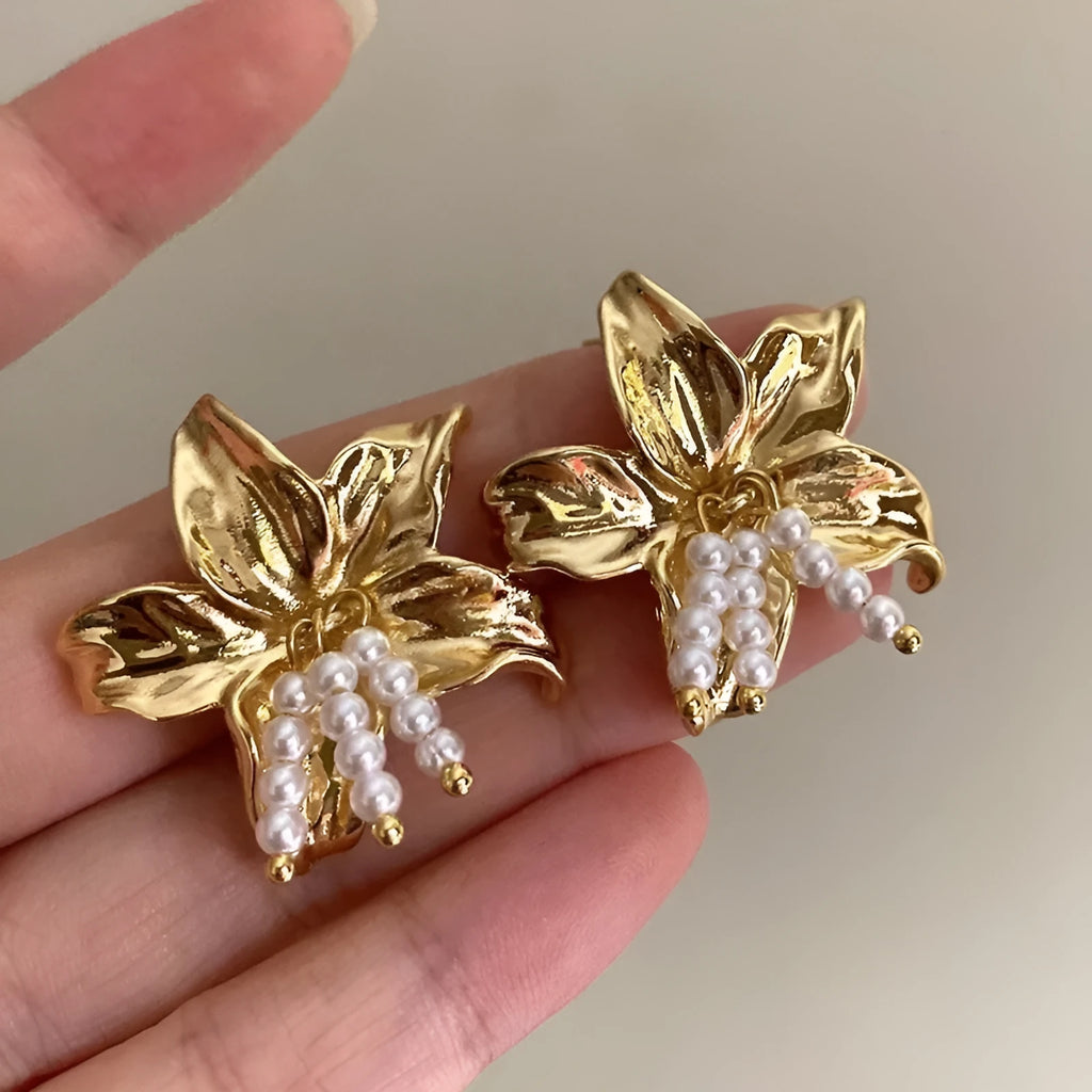 A pair of gold H1795 coloured flower-shaped drop earrings with a pearl centre.