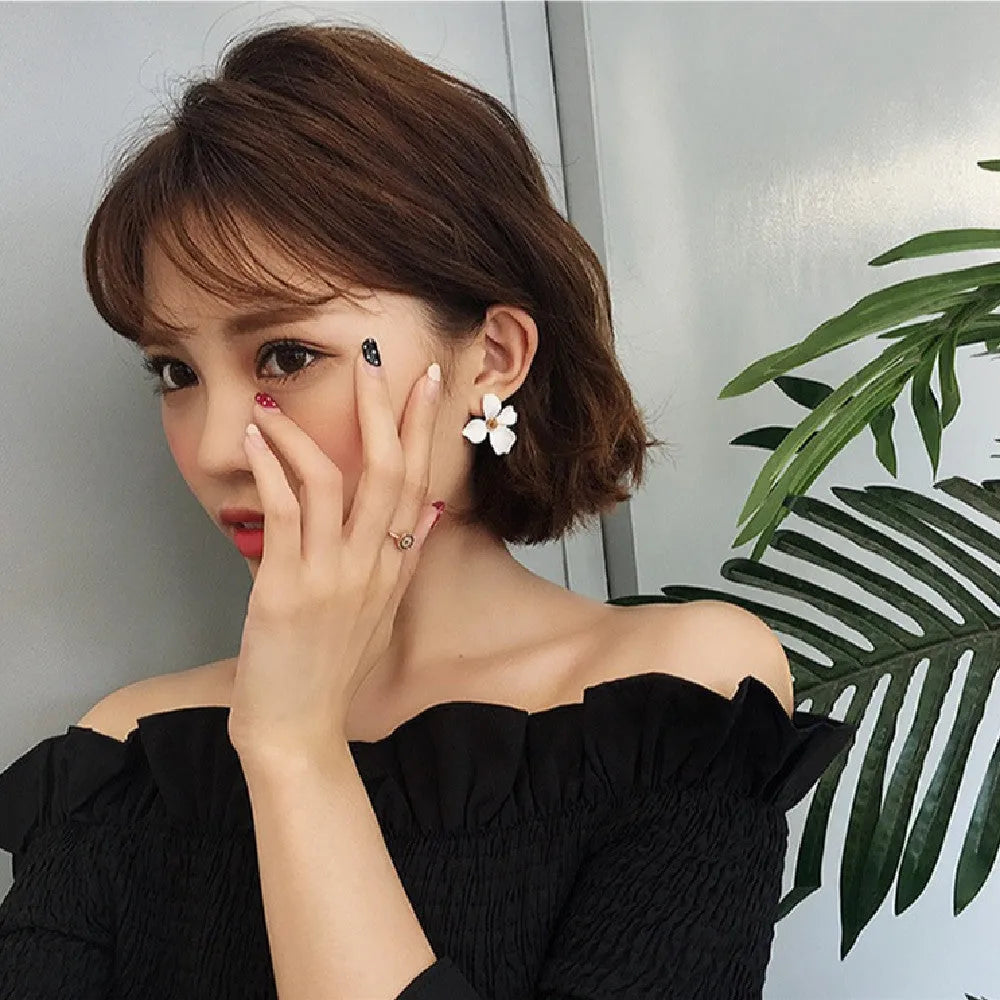 Flower-shaped stud earrings in white or pink colour with electroplated alloy construction