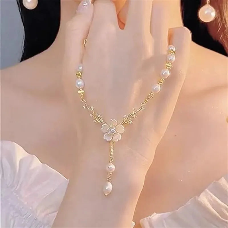 Alloy fashion necklace with pearl flower and rose decoration on a chain.