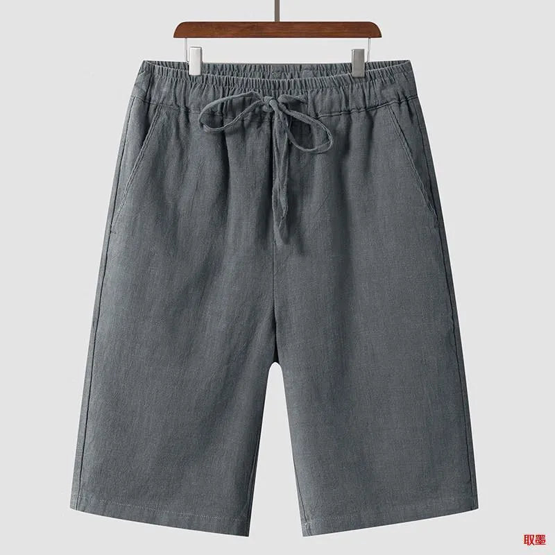 A pair of beige linen shorts for men with a loose, cropped fit and a mid-rise elasticated waistband.