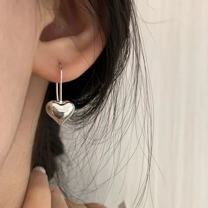 Silver Korean-style three-dimensional heart earrings with glossy finish and ear hook fastening