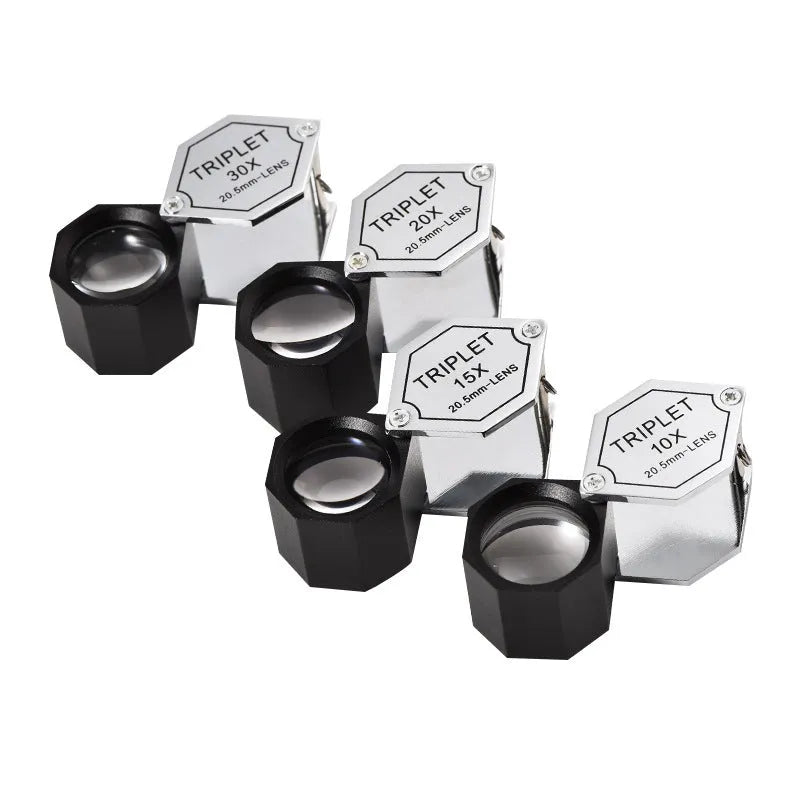 Handheld metal magnifying glass with optical glass lens for inspecting jewellery and coins.