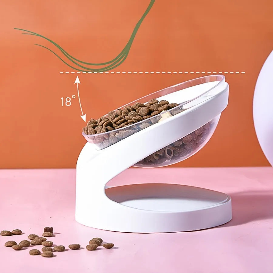White clear plastic tilted cat food bowl on a flat surface.