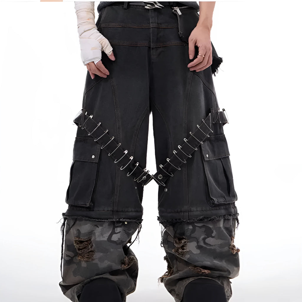 Men's grey camouflage pattern jeans with spliced panels and decorative pin details.