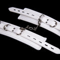White PU sponge bondage restraint set showing handcuffs, foot cuffs and neck scarf for discipline play