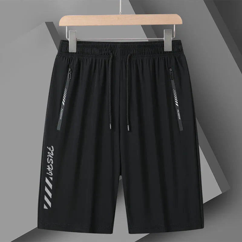 Man wearing loose fit black nylon sports shorts with an elastic waistband.