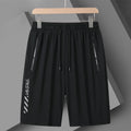 Man wearing loose fit black nylon sports shorts with an elastic waistband.