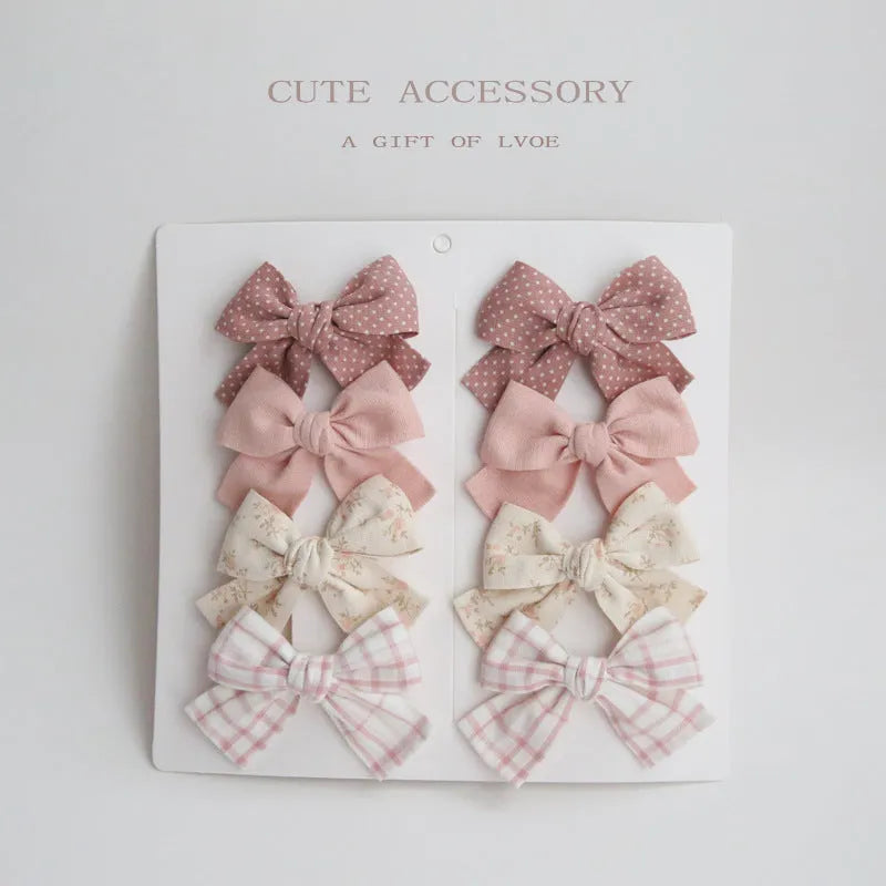 Children's dovetail bow hairclips in eight colour patterns including grid dots and floral designs