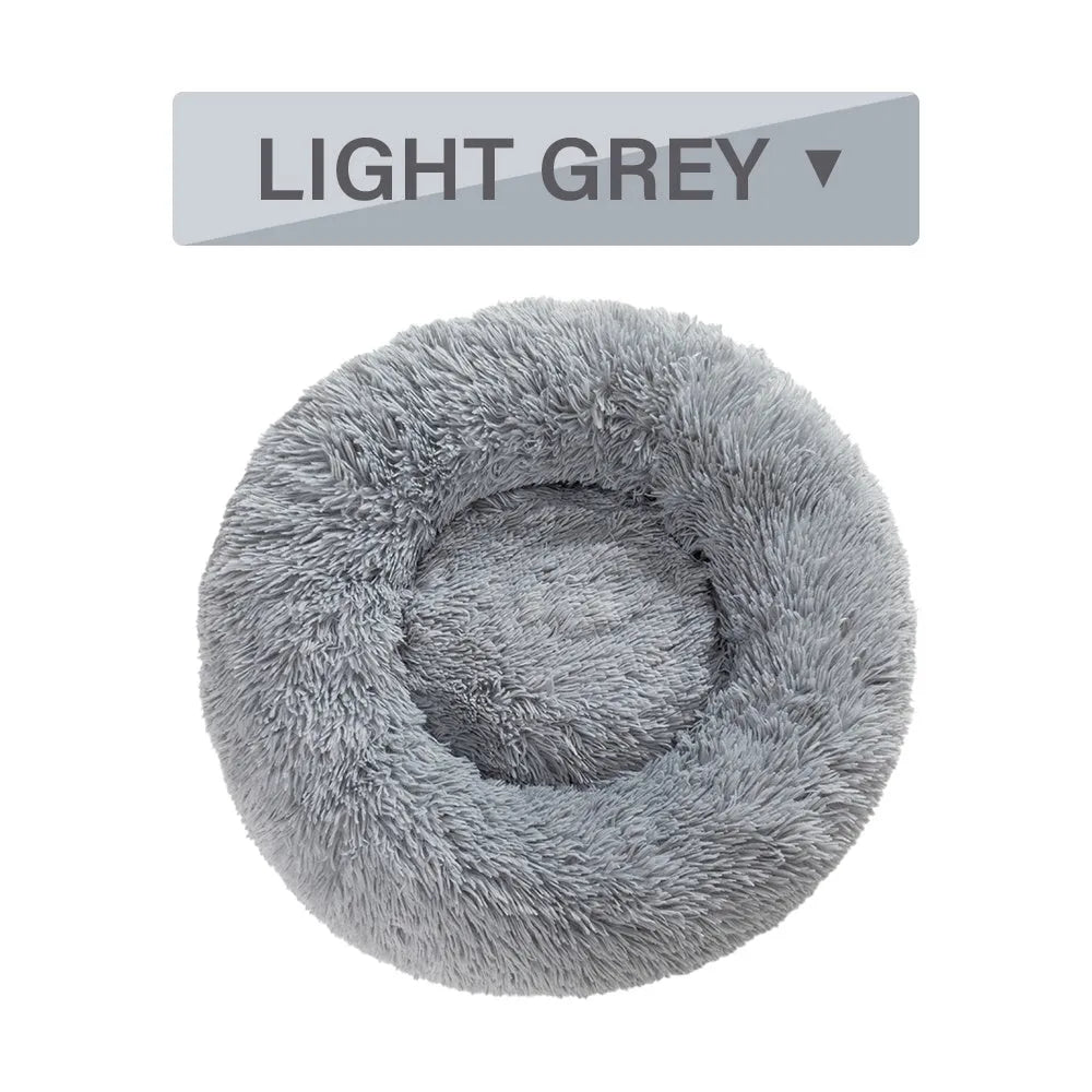 A round donut-shaped dog bed with a raised plush rim, shown in a light grey colour.