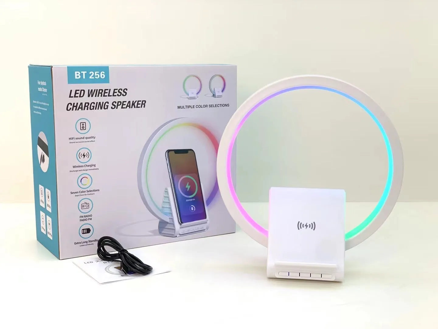 White smart Bluetooth speaker with wireless charging pad and ambient light on top.