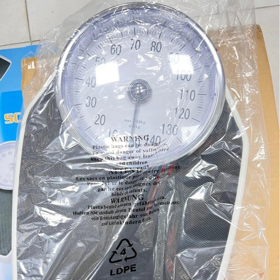 Black mechanical bathroom weight scale with large analogue dial on a simple platform.