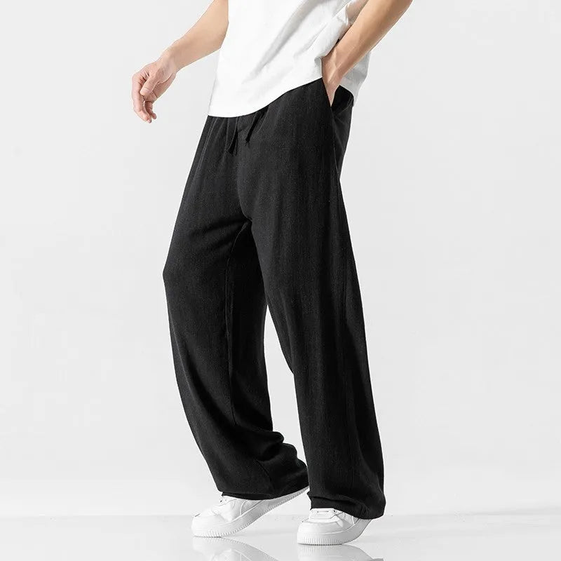 Men's beige bamboo fibre loose straight-leg casual trousers with a drawstring waist, shown on a hanger.
