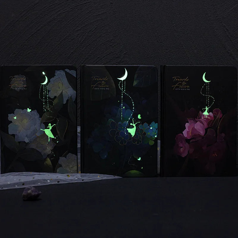 A5 notebook with luminous cover in blue, gold, light blue, or purple, open to show pages for colour illustration.