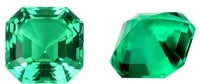 A loose cultivated emerald gemstone in Columbia green treasure colour on a white background.