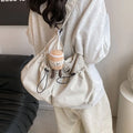 Soft green pleated polyester crossbody bag folded next to a mobile phone showing internal pocket.