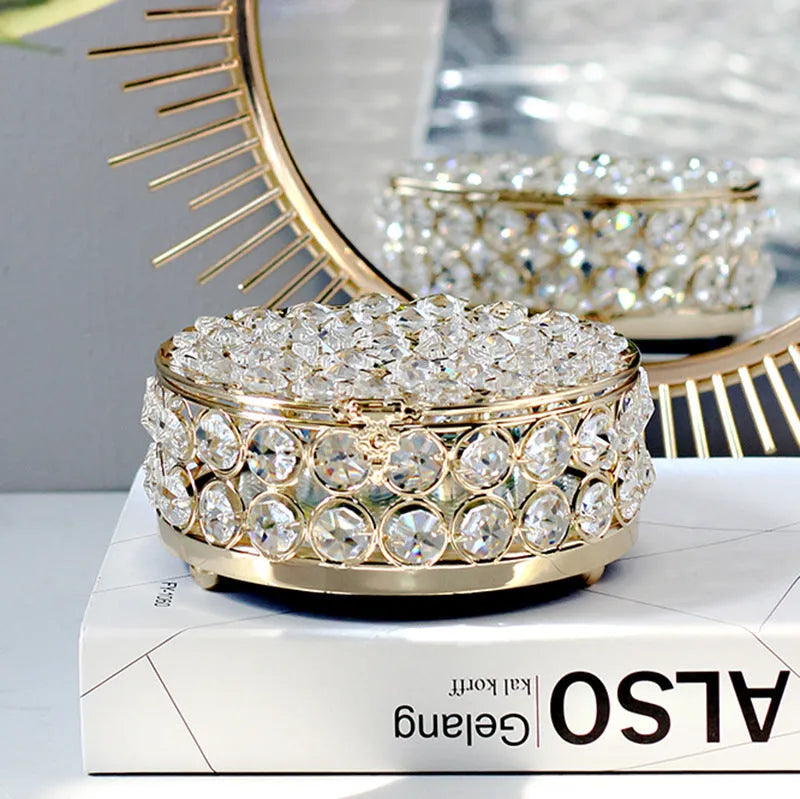 French gold metal jewellery box with a transparent crystal glass lid on a table.
