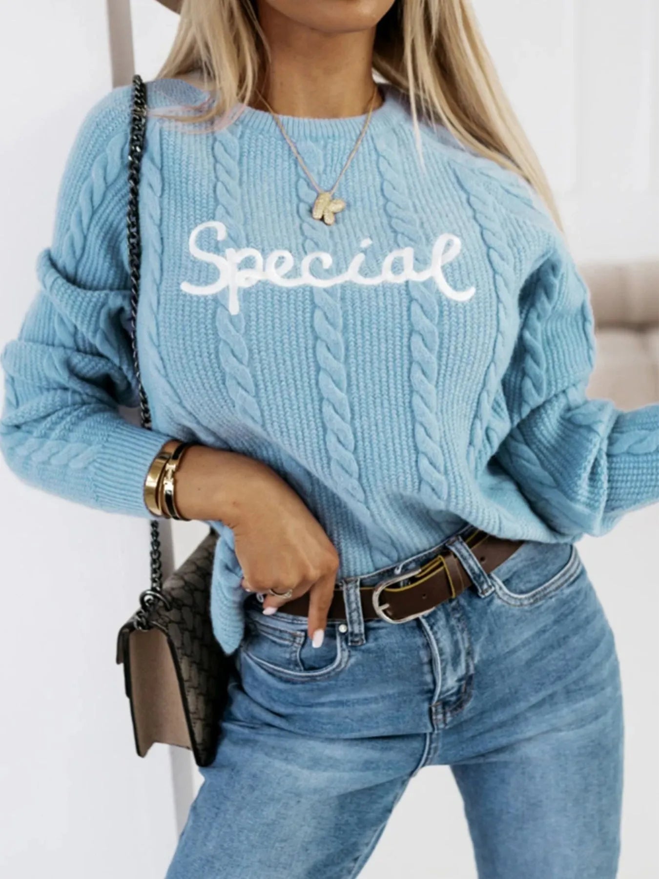 Blue crew neck pullover jumper with embroidered letter and number detailing on the front.