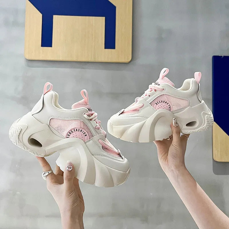 Women's pink casual sneakers with cross shoulder straps and a thick mid-heel sole.