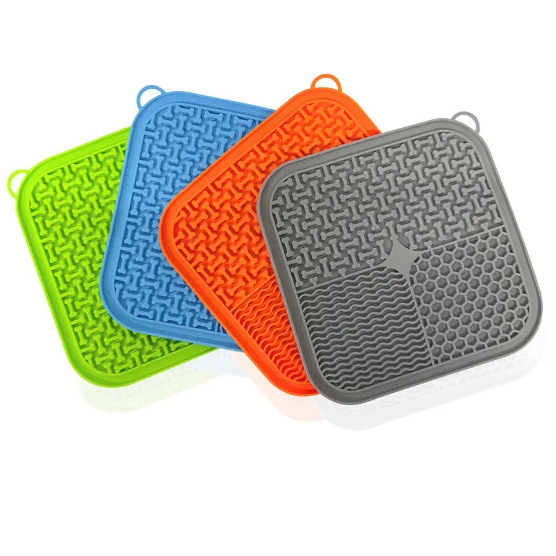 Square orange silicone dog licking mat with suction cups on back and textured surface