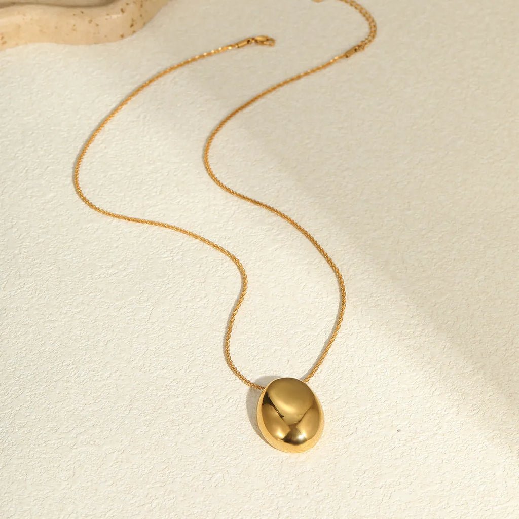Gold geometric pendant necklace with regular chain on black background showing 41-50cm length
