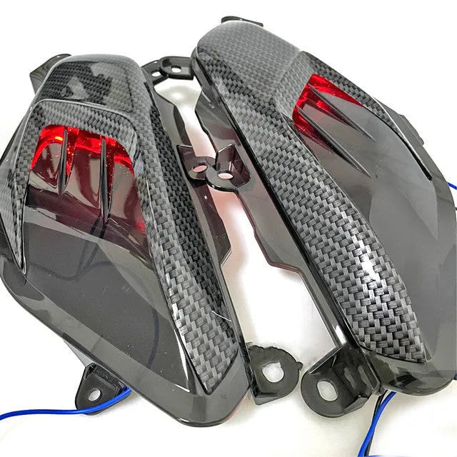 Pair of carbon fibre style LED side lamps for Yamaha NMAX scooter on a white background.