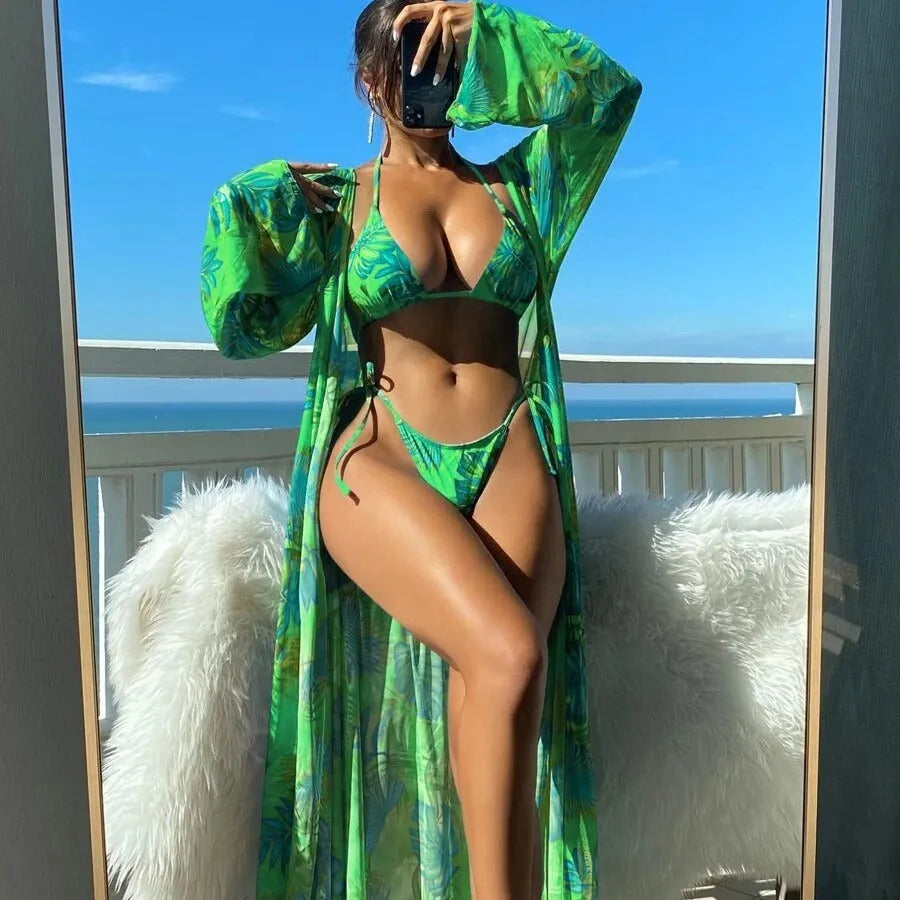 Women's blue long sleeve bikini top and banded briefs with a matching robe laid flat.