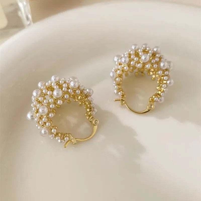 Gold women's copper earrings in a flower basket shape decorated with small rice-shaped beads.