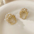 Gold women's copper earrings in a flower basket shape decorated with small rice-shaped beads.