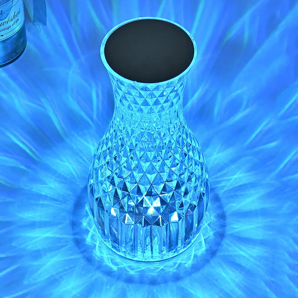 Vase-shaped crystal table lamp with LED lights and remote control on wooden bedside table