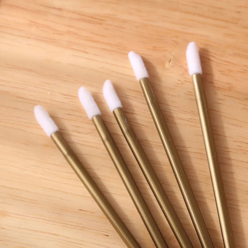 Pack of disposable lip brushes with flocked heads and coloured handles, shown in quantities from 200 to 500 pieces.