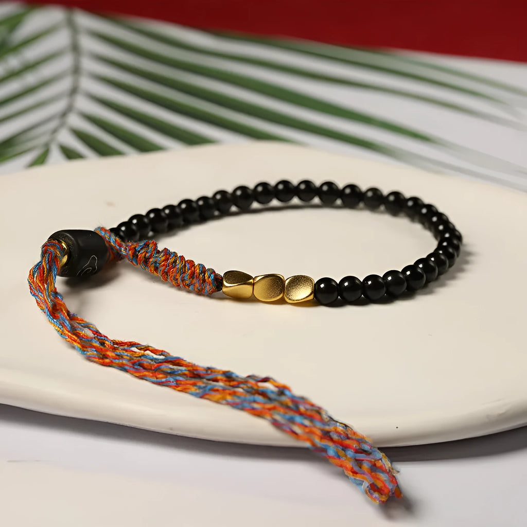 Hand-woven obsidian carrying strap bracelet showing 4mm width and woven texture detail
