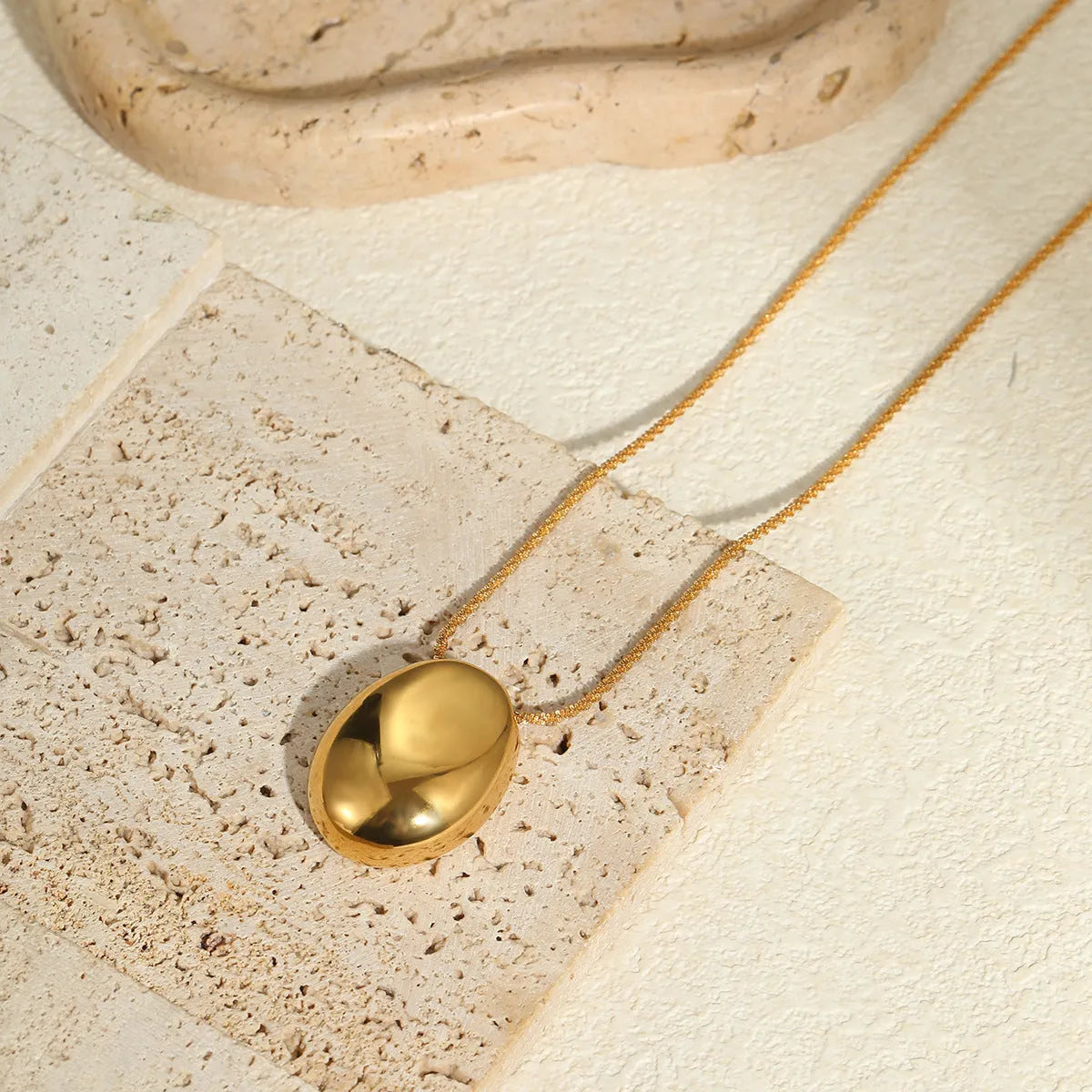 Gold geometric pendant necklace with regular chain on black background showing 41-50cm length