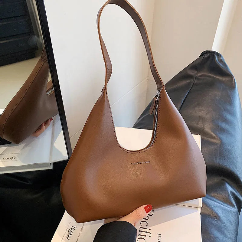 Brown retro PU shoulder handbag showing pillow shape, single strap, and organised interior with mobile phone pocket